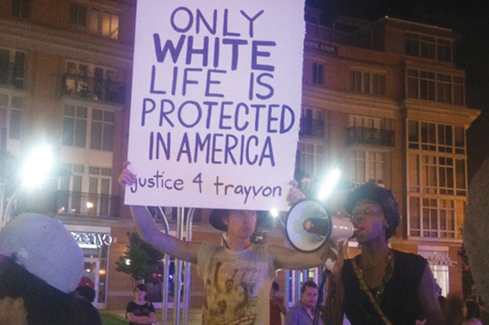 Демонстрант с плакатом «Америка защищает только жизнь белых!»