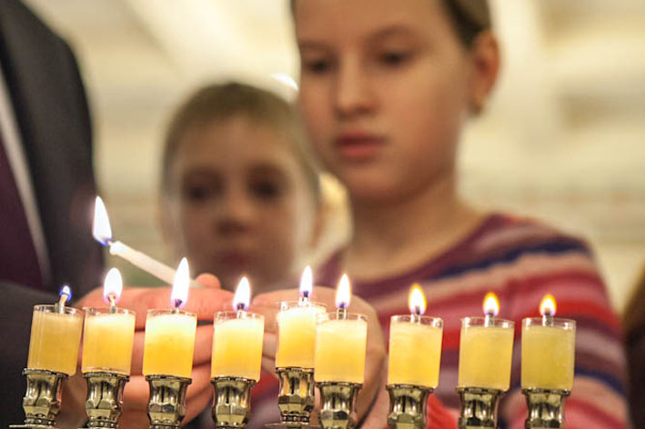 Дети зажигают ханукальную менору в московской синагоге