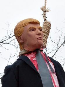 A tall tree with an effigy of President Donald Trump hanging from it by a hangman’s rope. The Trump effigy holds a Soviet flag, to emphasize Trump’s connections to Russian President Vladimir Putin. This is in front of a house on the south side of Oakdale Drive, between Fairfield Avenue and Hoagland Avenue, on the south side of Fort Wayne, Indiana. The owner is Mike Cunningham, a disabled Army veteran who despises President Donald Trump.