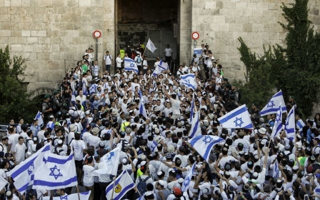 Far right Israeli supporters wave Israeli flags as they pass through the Damascus Gate in Jerusalem's Old City on May 24, 2017 to commemorate the Jerusalem Day, marking the establishment of Israeli control over the Old City following its capture in the Six-Day War of 1967.  / AFP PHOTO / Menahem KAHANA