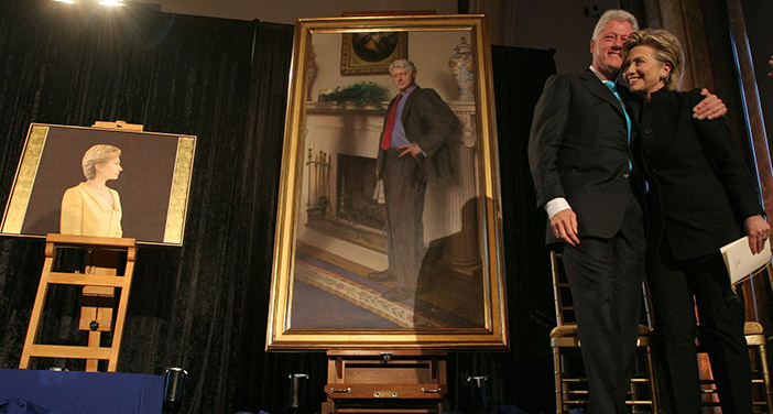 Чета Клинтон на фоне своих портретов