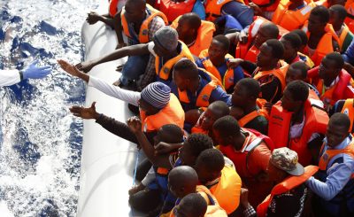 Handout photo shows a group of 104 sub-Saharan Africans on board a rubber dinghy preparing to board the NGO Migrant Offshore Aid Station ship Phoenix some 25 miles off the Libyan coast
