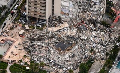 This aerial view, shows search and rescue personnel working on site after the partial collapse of the Champlain Towers South in Surfside, north of Miami Beach, on June 24, 2021. - The multi-story apartment block in Florida partially collapsed early June 24, sparking a major emergency response. Surfside Mayor Charles Burkett told NBCs Today show: My police chief has told me that we transported two people to the hospital this morning at least and one has died. We treated ten people on the site. (Photo by CHANDAN KHANNA / AFP)