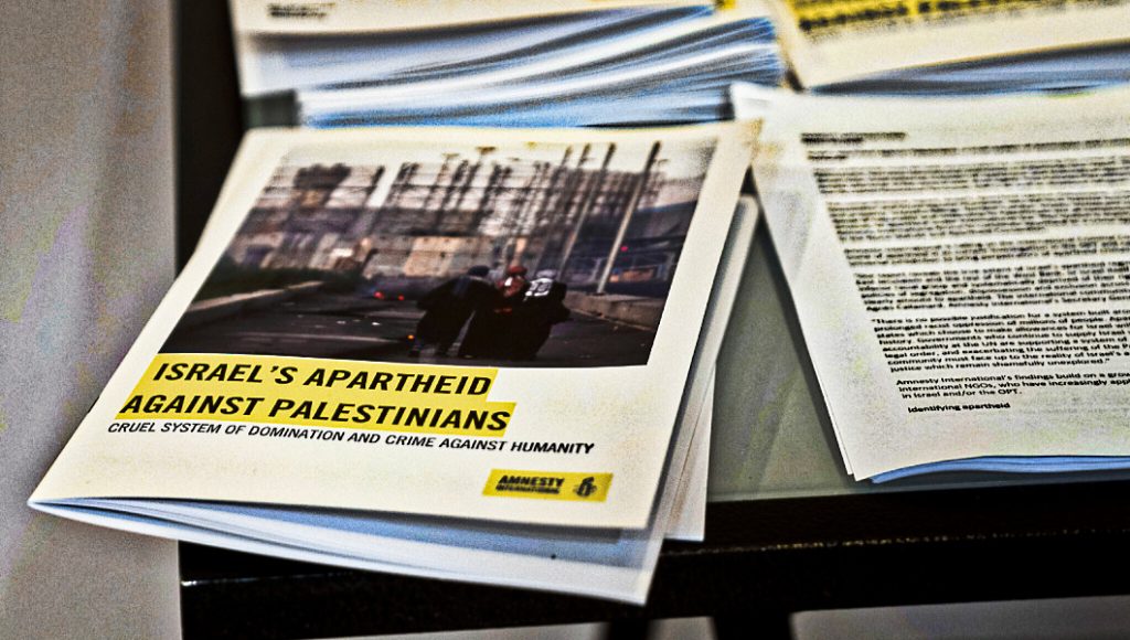 Copies of Amnesty International’s report “Israel’s Apartheid Against Palestinians,” are available for journalists at a press conference in Jerusalem, Tuesday, Feb. 1, 2022. Amnesty International said Tuesday that Israel has maintained “a system of oppression and domination” over the Palestinians going all the way back to its establishment in 1948, one that meets the international definition of apartheid.  (