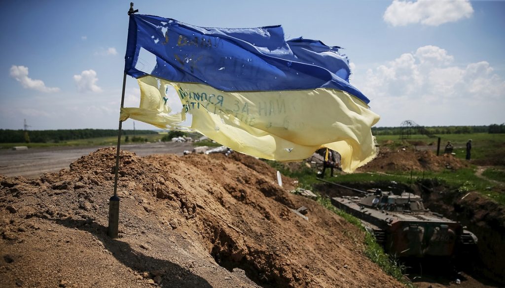 A tattered Ukrainian national flag flutters in the wind at a position held by the Ukrainian armed forces near the town of Maryinka, eastern Ukraine, June 5, 2015. Ukraine's president told his military on Thursday to prepare for a possible "full-scale invasion" by Russia all along their joint border, a day after the worst fighting with Russian-backed separatists in months.  REUTERS/Gleb Garanich - GF10000118271