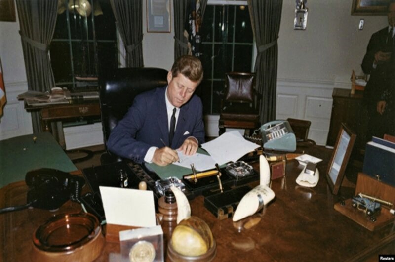 Президент США Джон Ф. Кеннеди подписывает прокламацию о запрете поставок наступательных вооружений на Кубу во время Карибского кризиса в Белом доме в Вашингтоне, округ Колумбия, 23 октября 1962 года (архивное фото)